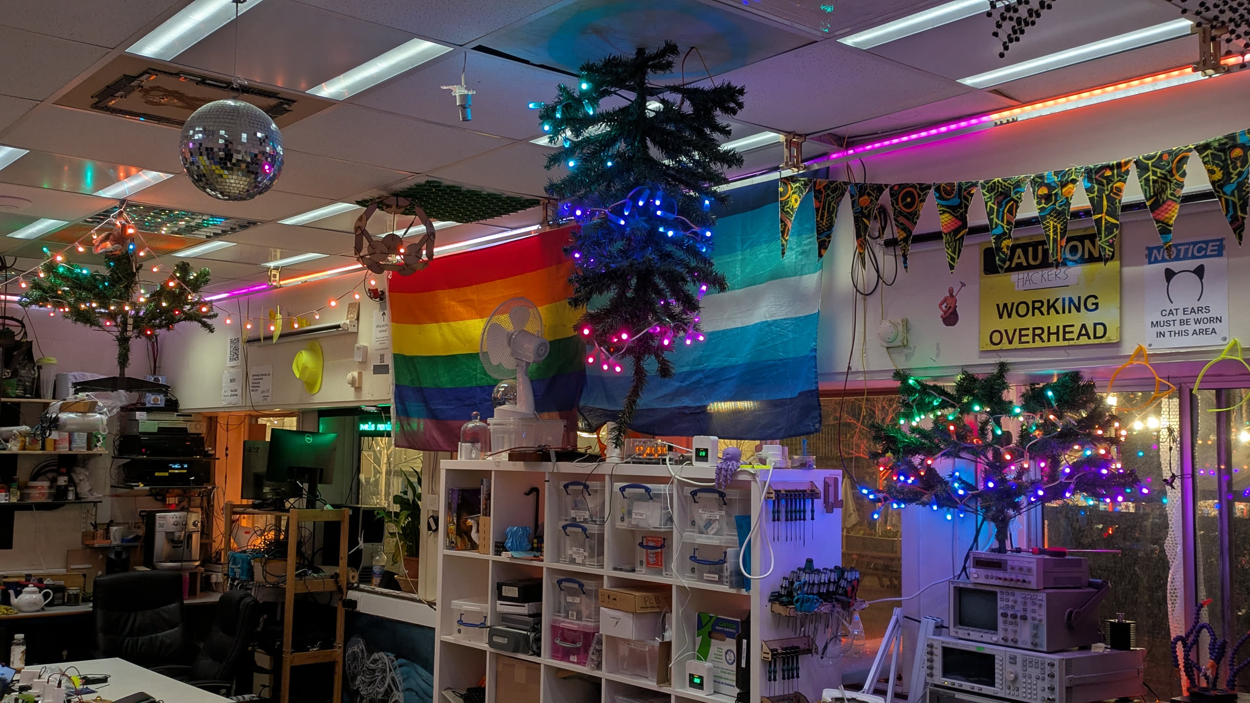 The ceiling of a room, with a christmas tree hanging down from the ceiling in various points.
